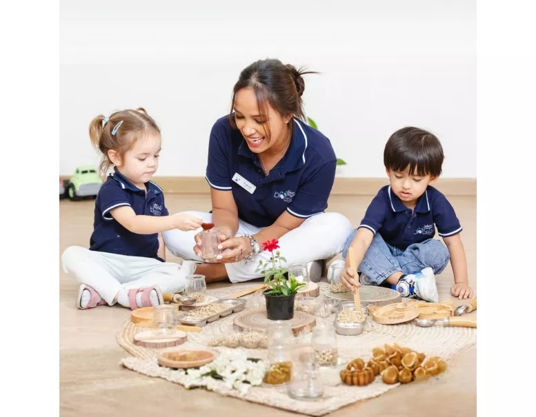 Happy toddler laughing during a sensory play activity at a British nursery in the UAE.